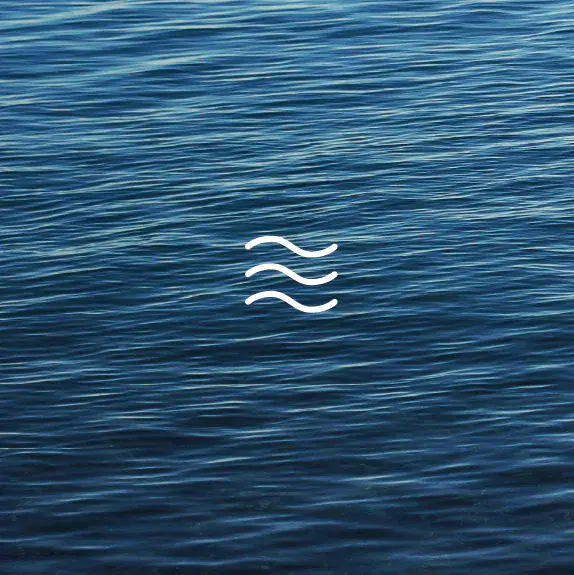 A wave on the water features a prominent white symbol, creating a striking contrast against the blue surface.