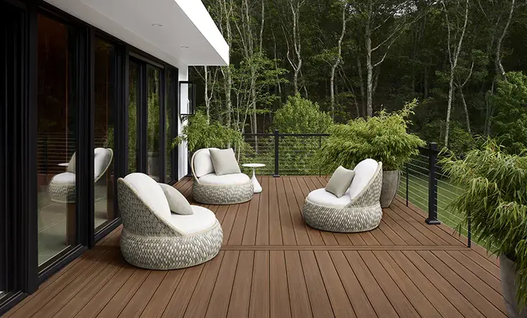 A deck featuring two chairs and a table, set for relaxation in an outdoor environment.