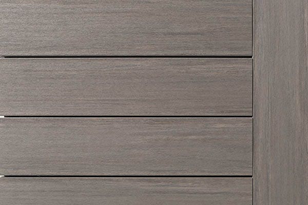 A decking swatch image of capped polymer deck boards in Coastline. The boards feature multi-tonal color blending and a low-gloss, wire-brushed finish for a premium hardwood look.