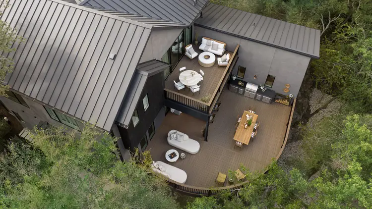 Drone shot of a two story deck with three distinct living areas and an outdoor kitchen