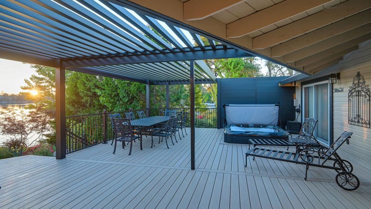 A sunken hot tub set into an AZEK Landmark Collection deck in French White Oak under a 4K aluminum slatted pergola, with a view across Lake of the Pines, photographed at sunset on a lakefront home in Auburn, California. Built by Stone Ridge Decking — custom decks across Northern California, serving Granite Bay, Folsom, Roseville, Lake Tahoe, Auburn, Sacramento, and Grass Valley. https://stoneridgedecking.com