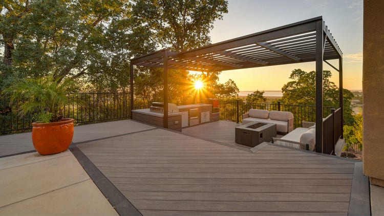 Deck featuring louvered pergola, Fortress powder-coated steel louvered pergola, Blaze outdoor kitchen with Dark Hickory cladding, and linear gas fire pit. Built by Stone Ridge Decking, a custom deck builder serving El Dorado Hills, Folsom, Lake Tahoe, Auburn, Sacramento, Grass Valley, Cameron Park, and surrounding Northern California communities. https://stoneridgedecking.com