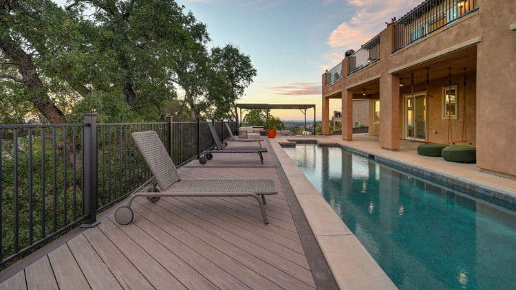 Deck featuring pool deck railing, Fortress powder-coated steel louvered pergola, Blaze outdoor kitchen with Dark Hickory cladding, and linear gas fire pit. Built by Stone Ridge Decking, a custom deck builder serving El Dorado Hills, Folsom, Lake Tahoe, Auburn, Sacramento, Grass Valley, Cameron Park, and surrounding Northern California communities. https://stoneridgedecking.com