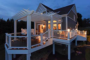 Second-story composite deck with pergola at dusk