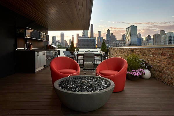 Rooftop deck featuring TimberTech AZEK Vintage Collection in English Walnut with two orange chairs