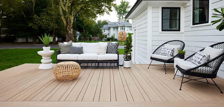 A Small deck includes two black chairs and a matching sofa with simple lines and rattan decor.