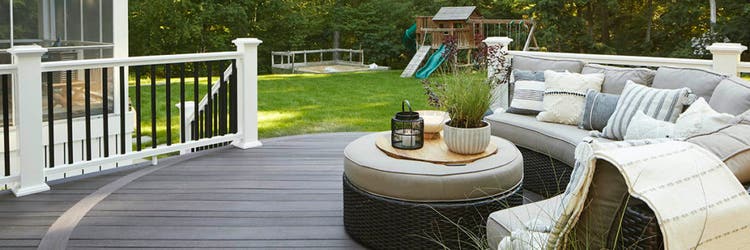 A composite deck made with Dark Hickory multi-width decking features a curved couch