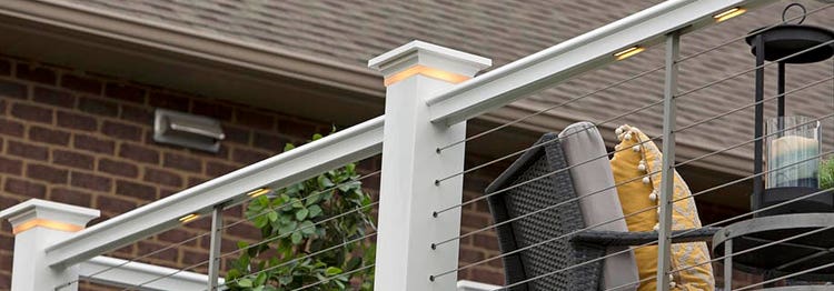 Shot from below of a deck railing with under rail lights and post cap lights