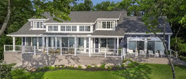Large home with many windows across the top floor built into a hill