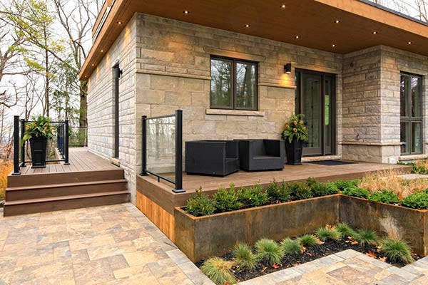 A mid-century modern home features modern front porch ideas like echoed black elements on home and porch