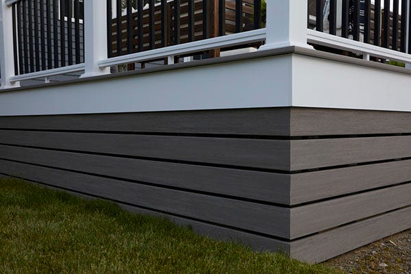 Multi colored deck with gray decking and white PVC skirting