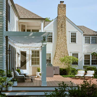 Two tone deck color schemes with a large family home and white pergola over a low deck