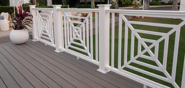 Three white square web panels seperate a deck and lawn with a repeating geometric square pattern.