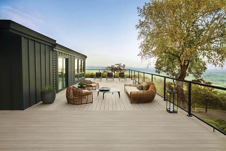 Expansive light tan deck with glass infill railing overlooks rolling hills