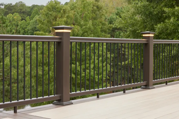 Brown railing that runs the perimeter of a light tan deck