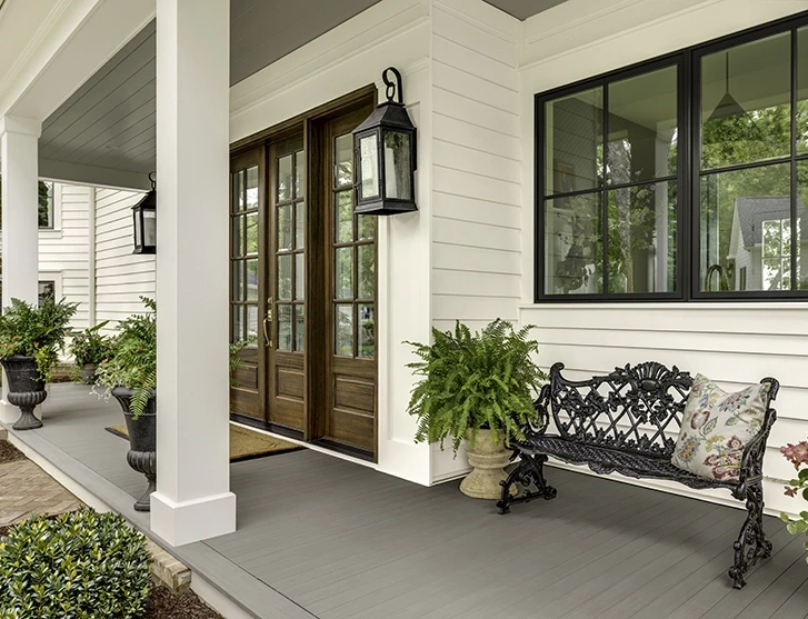 Angled view of front porch with a wrought iron bench