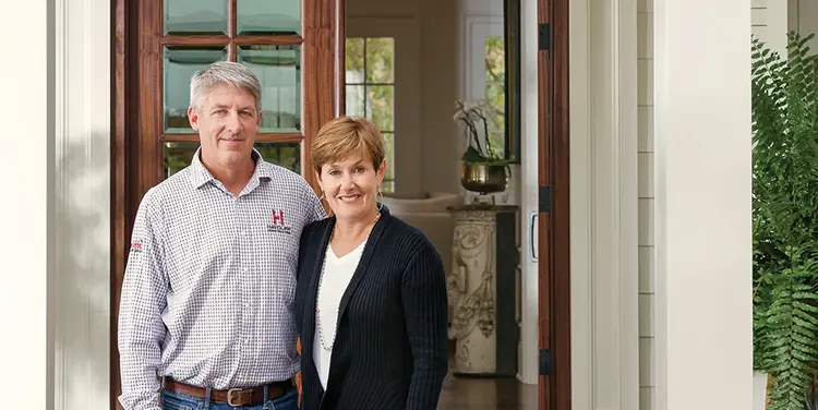 Mary and Patrick pose for a portrait on their porch