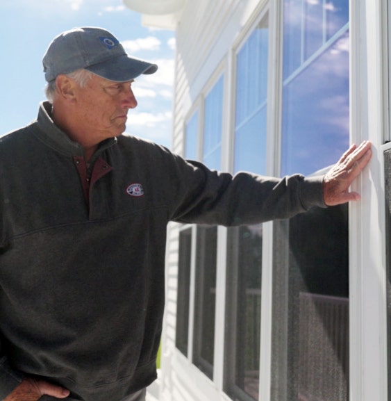 Joe Guenther looking through an external window at the Pentwater Yacht Club.