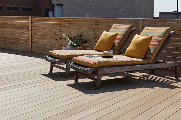 Sunny rooftop deck with two lounge chairs and TImberTech AZEK VIntage Collection Weathered Teak decking