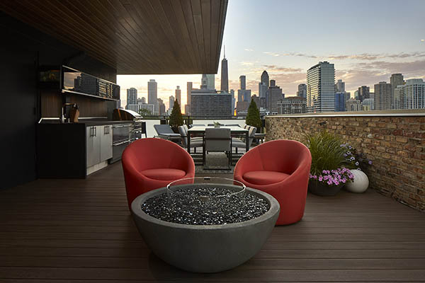Rooftop deck featuring TimberTech AZEK Vintage Collection in English Walnut with two orange chairs