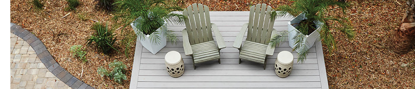 Decking boards featuring TimberTech AZEK Harvest Collection in Slate Gray with two Adirondack chairs