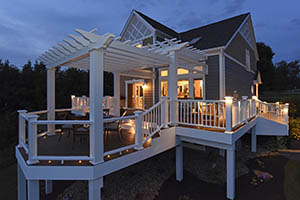 Second-story composite deck with pergola at dusk