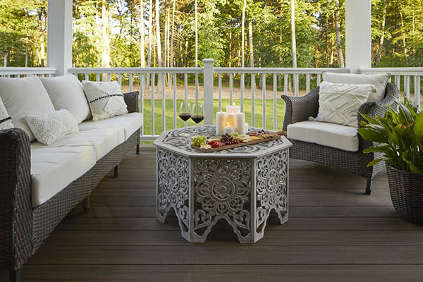 A covered composite deck with ornate furniture and decor