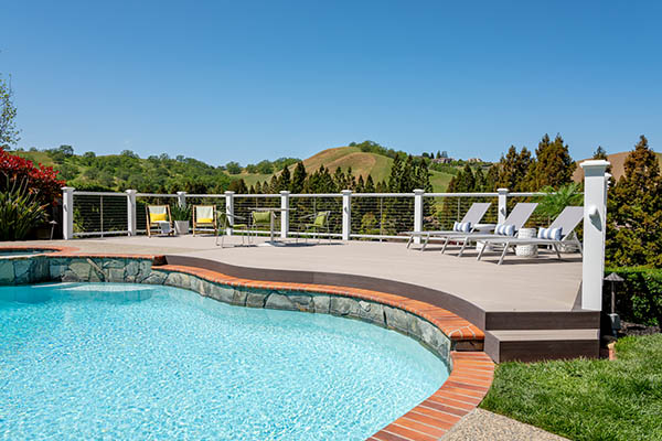 A poolside composite deck that curves to the shape of the pool