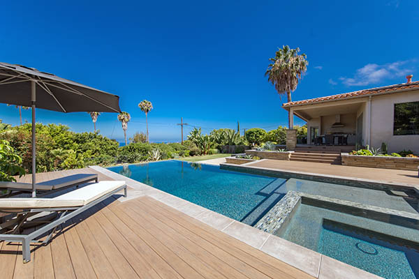 A composite deck surrounds an in-ground pool