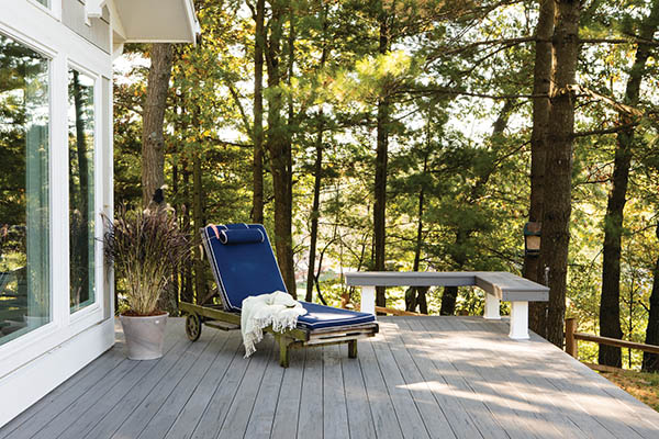 Wraparound deck and lounge chair bordered by forest
