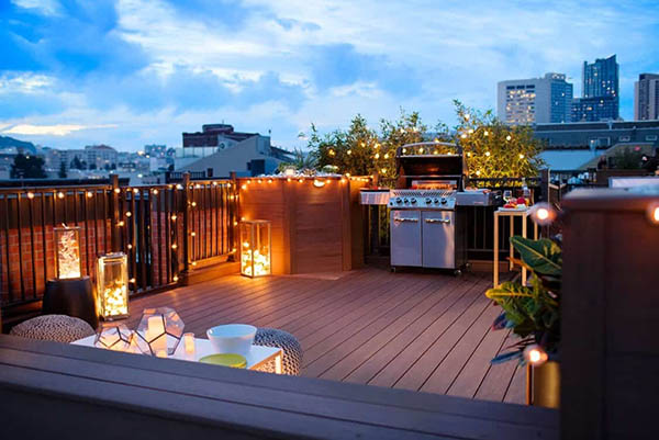 Gated rooftop patio with fairy lights and grill
