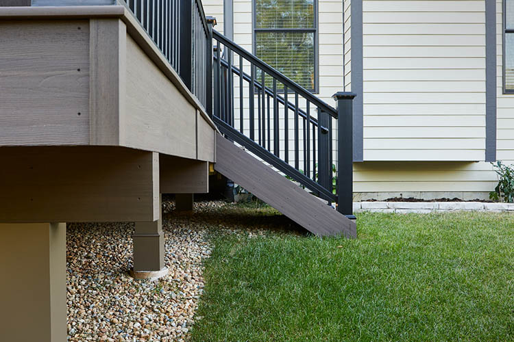 How to plan a deck project featuring sideview of deck stairs leading to lawn
