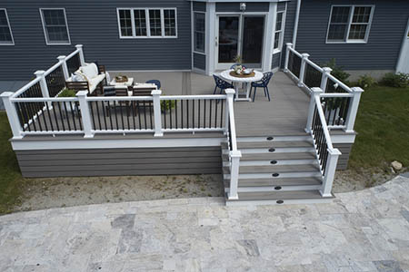 Composite decking vs wood and wood deck vs composite deck featuring large home and furnished deck with stairs