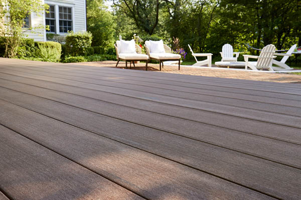 Deck over concrete patio featuring lawn chairs and TimberTech Mahogany decking