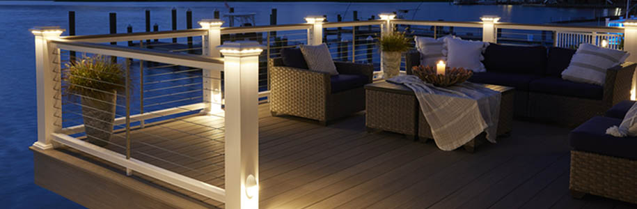 Deck railing ideas and deck baluster ideas on nighttime lakeside furnished deck with post cap lights