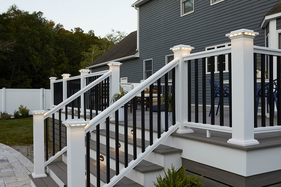 Backyard of single family home with raised deck and post cap lighting