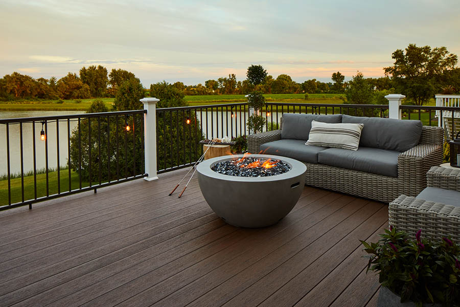Deck railing ideas and deck baluster ideas with round firepit on furnished lakeside deck
