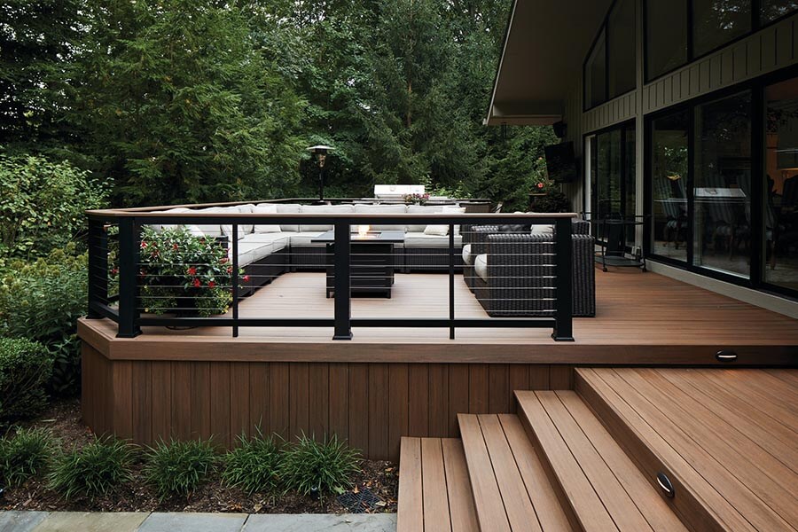 Furnished raised deck and stairs surrounded by lush forest