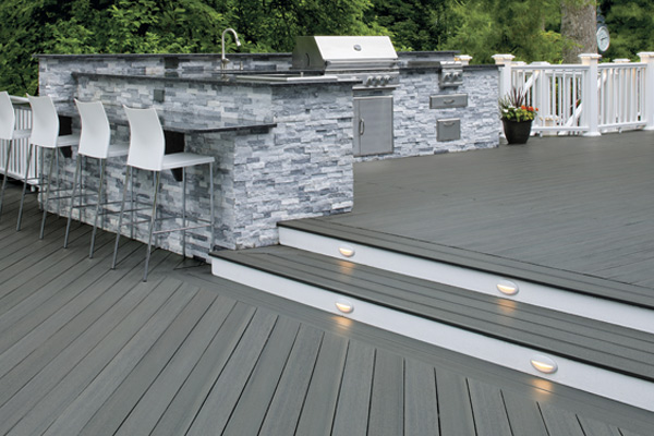 Outdoor kitchen with bar stools and composite deck from TimberTech EDGE