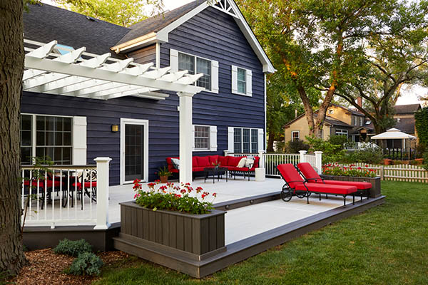 Two tone deck color schemes and deck color combinations on low furnished deck in backyard of large blue home