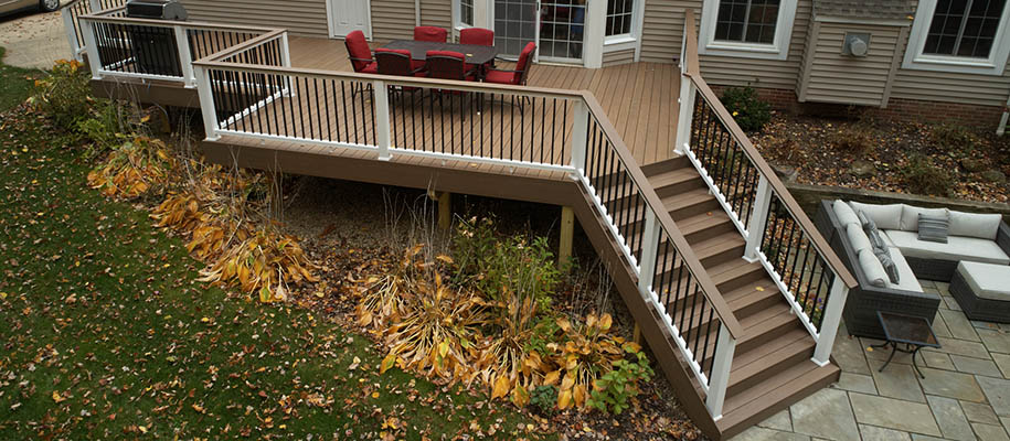 Two tone deck color schemes and deck color combinations in a leafy home backyard with patio furniture