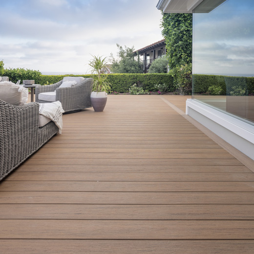 Box hedges line the perimeter of a modern coastal composite deck