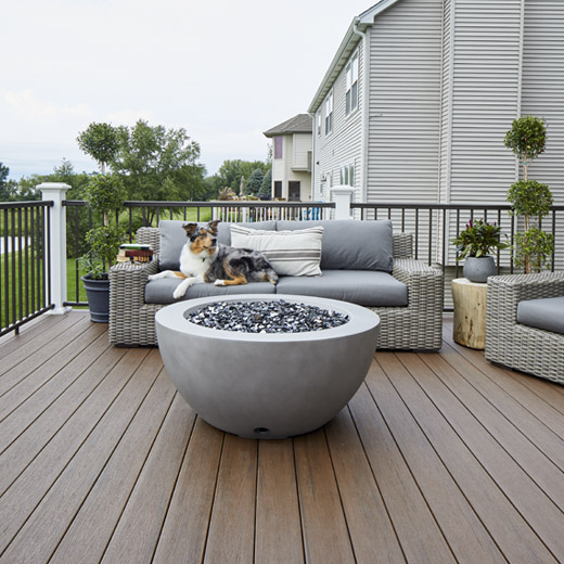 Dog lounging on a couch sitting on a second-story composite deck