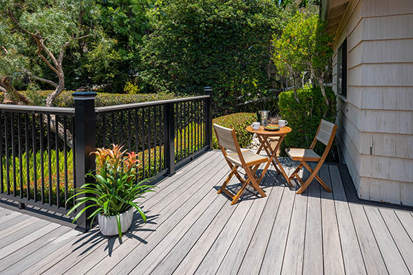 Modern gray composite deck with a sleek black metal railing with a gray deck board top rail