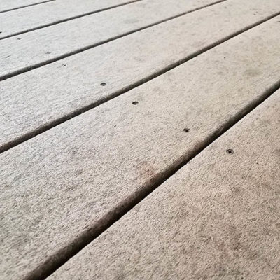 Close up shot of uncapped composite deck boards showing signs of fading