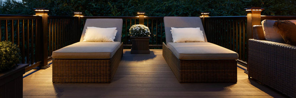 Deck lights in the railing caps illuminate the perimeter of a richly hued composite deck