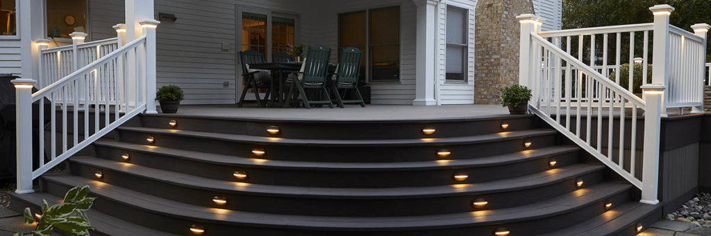 Lights for deck stairs include deck lights in the risers of curved cascading stairs