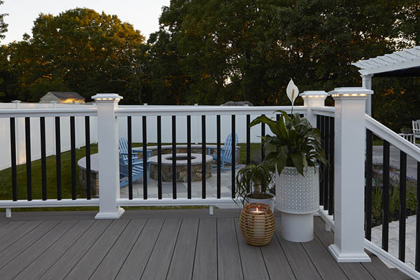 Lights for deck railing posts include lighted island caps in a white composite railing