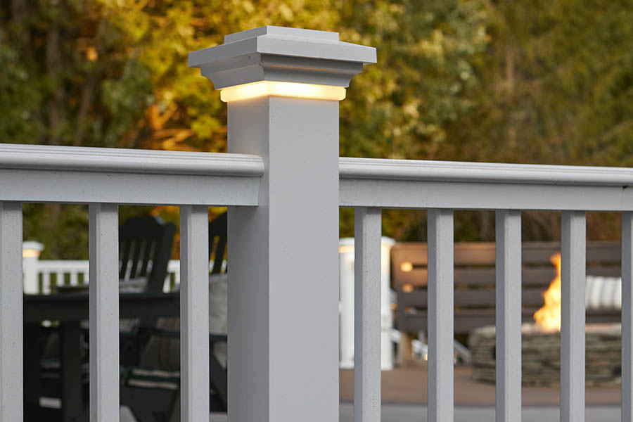 Deck lights include a post cap light in a white composite railing post