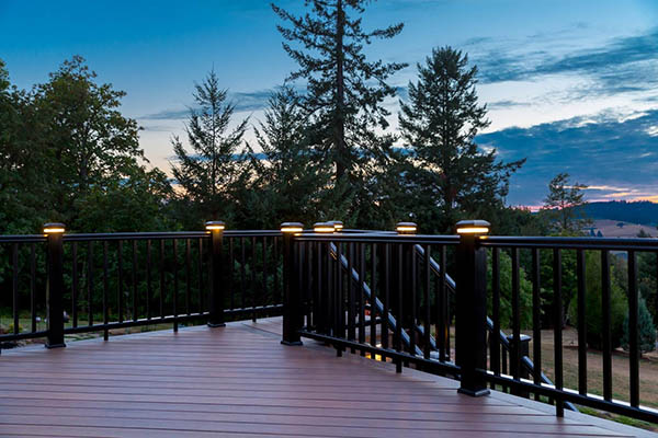 Lights for deck railing posts create a warm glow at twilight